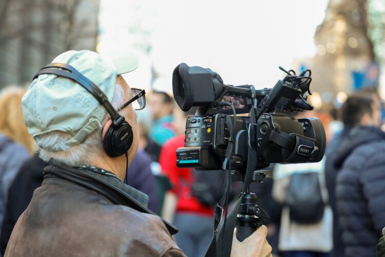 Operador de cámara grabando un evento urbano con equipo profesional